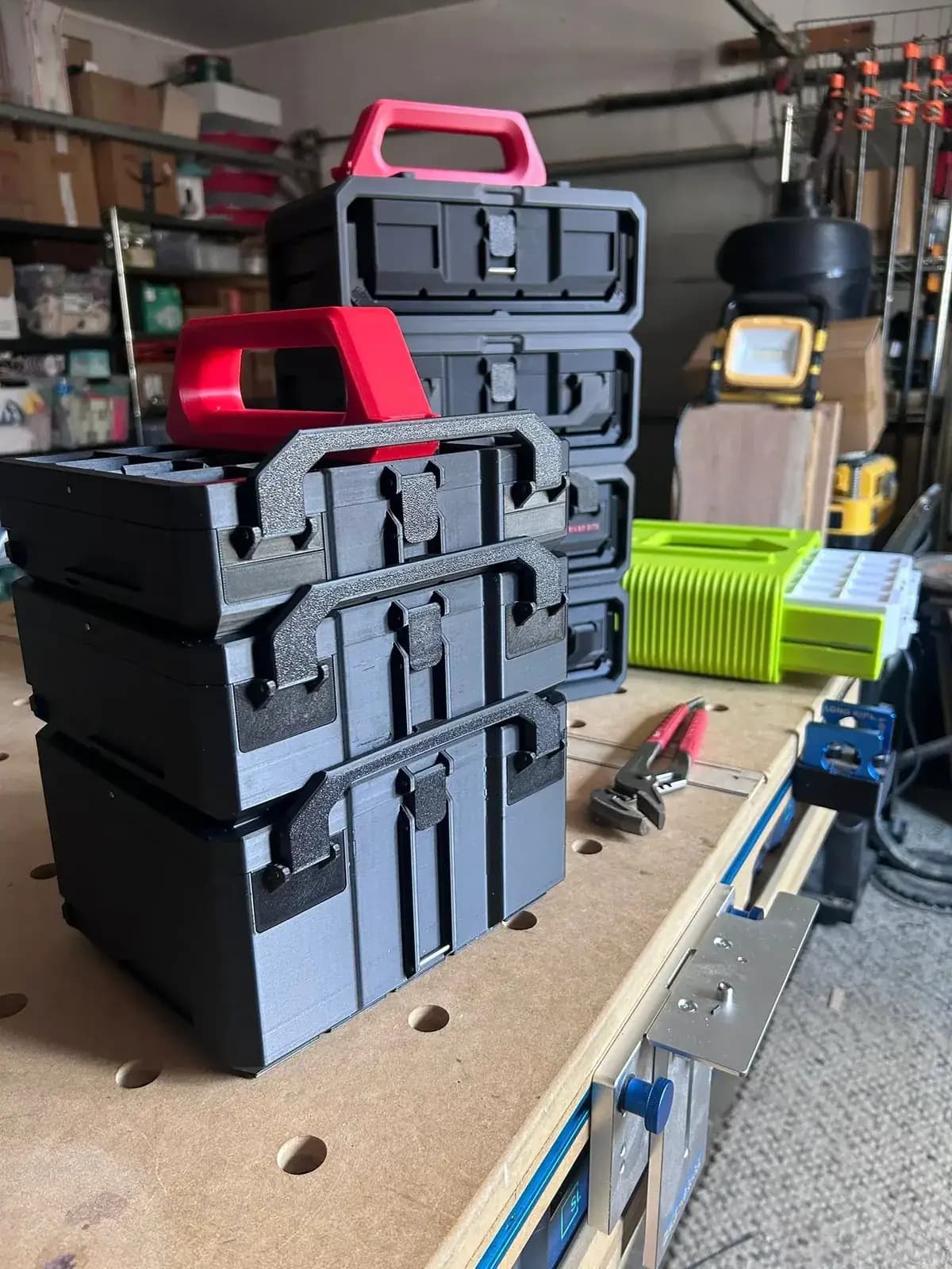 Stacked Graphite Modular Gridfinity-compatible storage boxes with carry handles on a workshop bench